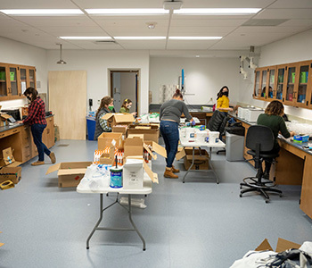 Student volunteers with the Science Policy Initiative assemble lab kits.